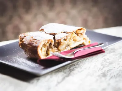 a piece of pastry on a plate with a fork at Prissianerhof in Tesimo
