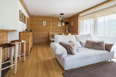 a living room with a white couch and wooden walls at Chalet Belvedere - Dolomiti Skyline in Cortina dʼAmpezzo