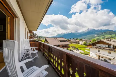 a balcony with chairs and a view of mountains at Chalet Belvedere - Dolomiti Skyline in Cortina dʼAmpezzo