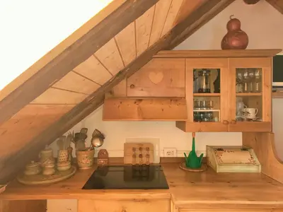 an attic kitchen with a sink and wooden cabinets at So close to Sellaronda lifts! in Campitello di Fassa