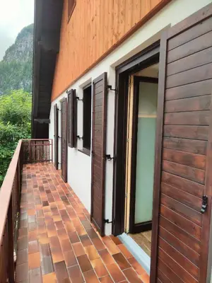 a balcony of a house with wooden doors at So close to Sellaronda lifts! in Campitello di Fassa