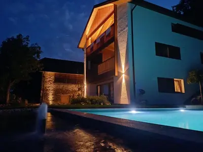 a house with a swimming pool in front of a building at Hofgut Antlas in Collalbo
