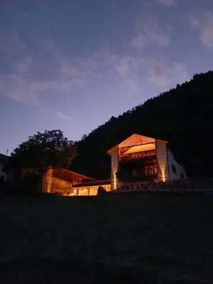a large building with lights on it in a field at Hofgut Antlas in Collalbo