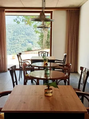 a dining room with tables and chairs and a large window at Hofgut Antlas in Collalbo