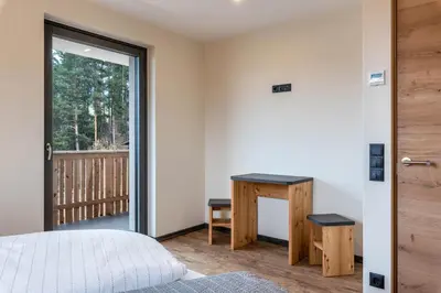 a bedroom with a bed and a desk and a window at Villa Lara Zirbe in Castelrotto