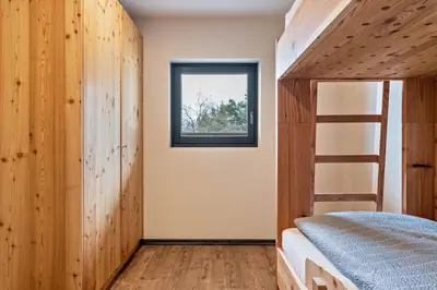 a bedroom with a bunk bed and a window at Villa Lara Zirbe in Castelrotto