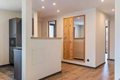 a kitchen with white walls and a wooden door at Villa Lara Zirbe in Castelrotto