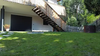 a house with a garage and a wooden stairway at Villa Lara Zirbe in Castelrotto