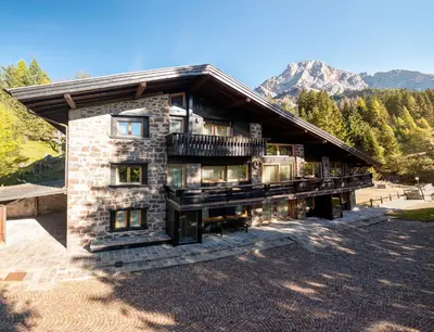 a stone house with a balcony on top of it at Villa Speronella in San Martino di Castrozza