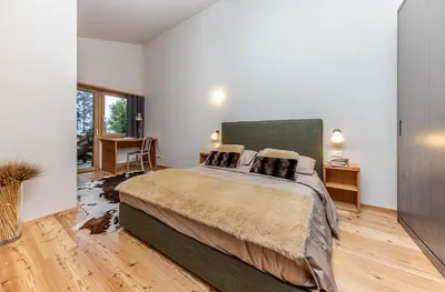 a bedroom with a large bed and a desk at Villa Speronella in San Martino di Castrozza