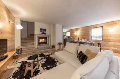 a living room with a white couch and a fireplace at Villa Speronella in San Martino di Castrozza