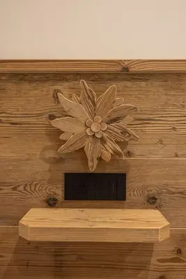 a wooden flower decoration on a wooden wall at Incantevole appar chalet nuovo in Borca di Cadore