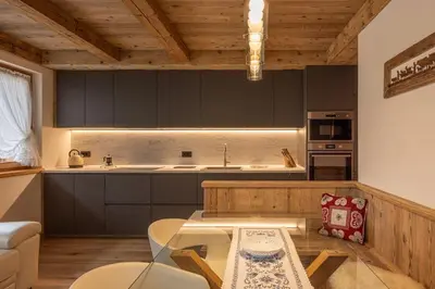 a kitchen with black cabinets and a table at Incantevole appar chalet nuovo in Borca di Cadore
