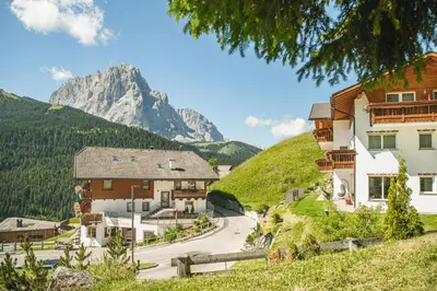 a village with a mountain in the background at Hotel Daniel Apartments in Selva