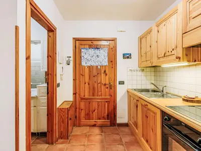 a kitchen with wooden cabinets and a wooden door at Apartment Condominio Val di Fassa-2 by Interhome in Alba di Canazei