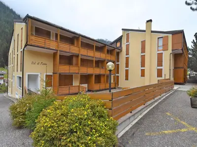 a building with a wooden fence in a parking lot at Apartment Condominio Val di Fassa-2 by Interhome in Alba di Canazei