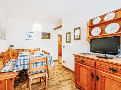 a dining room with a table and a tv on a cabinet at Apartment Condominio Val di Fassa-2 by Interhome in Alba di Canazei