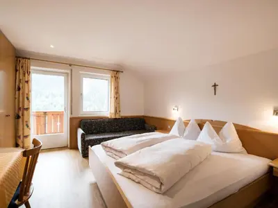 a bed in a room with a wooden wall at Apartment Ornella-3 by Interhome in Ortisei
