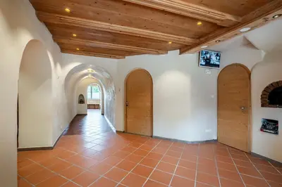 an empty hallway with wooden doors and a tile floor at Kaiserau 1907 in Collalbo