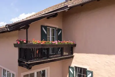 a balcony with flowers on a building at Kaiserau 1907 in Collalbo