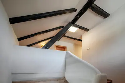 a room with a white wall and wooden beams at Kaiserau 1907 in Collalbo