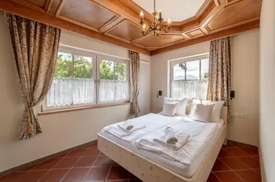 a bedroom with a large white bed with windows at Kaiserau 1907 in Collalbo