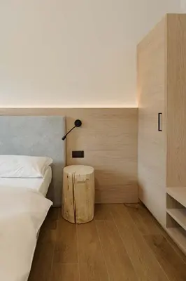 a bedroom with a bed and a lamp on a table at Appartamenti Terme Viola in Pozza di Fassa