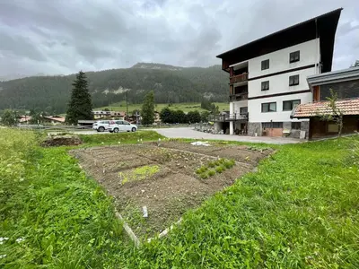 a garden in a field next to a building at Appartamenti Terme Viola in Pozza di Fassa