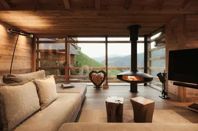 a living room with a couch and a fireplace at Lominus Dolomites Luxury Chalet for 2 in San Martino in Badia