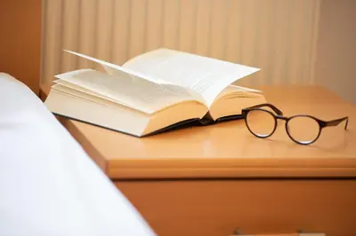 an open book and pair of glasses sitting on a desk at Göllerhof in Caldaro