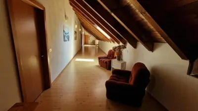 a hallway with couches and chairs in a building at Malga Arpaco- camere e ristorante in Cinte Tesino