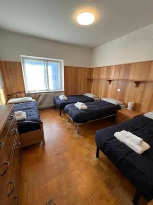 a room with four beds in a room with at Appartamento 135mq - Splendida Vista Sul Lagorai in Cavalese