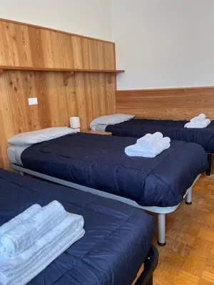 three beds in a room with blue sheets and towels at Appartamento 135mq - Splendida Vista Sul Lagorai in Cavalese
