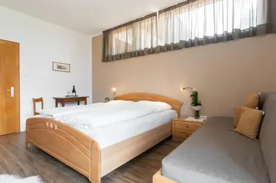 a bedroom with a large bed and a window at Sonnenhof- Urlaub auf den Bauernhof in Montagna