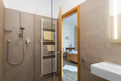 a bathroom with a shower and a sink at Sonnenhof- Urlaub auf den Bauernhof in Montagna