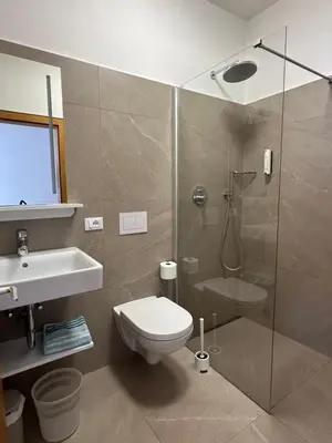 a bathroom with a shower and a toilet and a sink at Sonnenhof- Urlaub auf den Bauernhof in Montagna