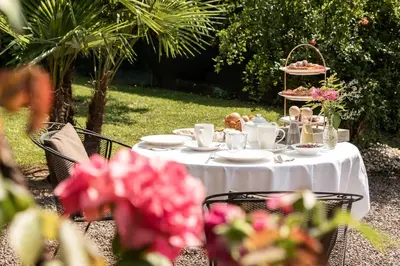 a white table with food on it with flowers at Sonnenhof- Urlaub auf den Bauernhof in Montagna