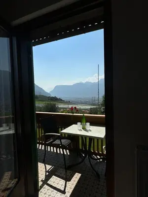 a table and chairs on a balcony with a view at Sonnenhof- Urlaub auf den Bauernhof in Montagna