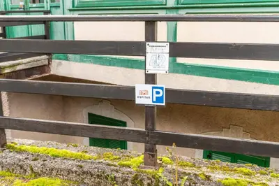 a parking sign on a fence next to a building at Dimora al Penegal, Passo Mendola Ospitar in Mendola