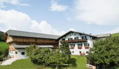 a large white building with a black roof at Kreuzerhof in Siusi