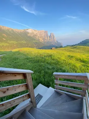 two benches sitting on top of a field of grass at Kreuzerhof in Siusi