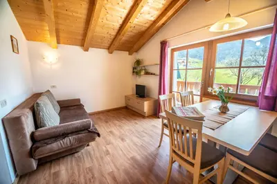 a living room with a table and a couch at Kreuzerhof in Siusi