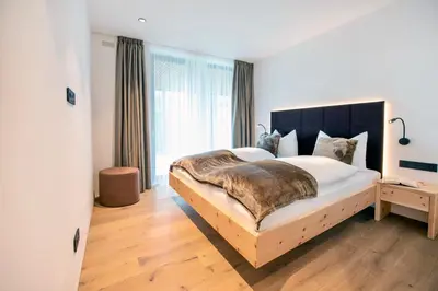 a bedroom with a large bed with a large window at Villa Barleit in Caldaro