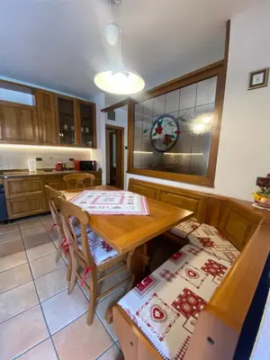 a kitchen with a table and a table and chairs at Appartamento Madama in Falcade