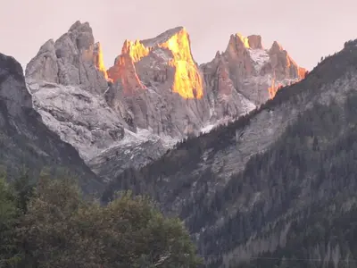 a mountain range with the sun shining on it at Appartamento Madama in Falcade