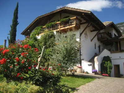 a house with a balcony and flowers in front of it at Gfillhof Ferienwohnung 3 in Eppan an der Weinstrasse ST. Pauls