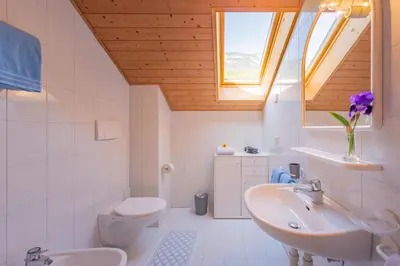 a bathroom with a sink and a toilet and a window at Gfillhof Ferienwohnung 3 in Eppan an der Weinstrasse ST. Pauls