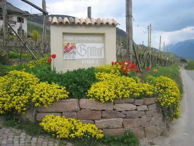a sign for a vineyard with yellow and red flowers at Gfillhof Ferienwohnung 3 in Eppan an der Weinstrasse ST. Pauls