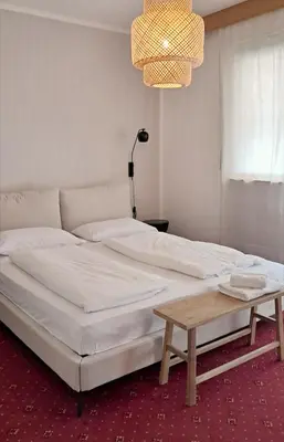 a bedroom with a large bed with a chandelier at haus e Apartment 2 in Lana