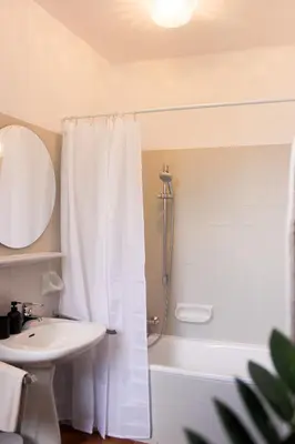 a bathroom with a shower curtain and a sink at haus e Apartment 2 in Lana